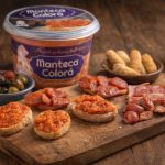 Manteca colorá de Icarben presentada en tabla de madera con tostas, aceitunas y embutido andaluz